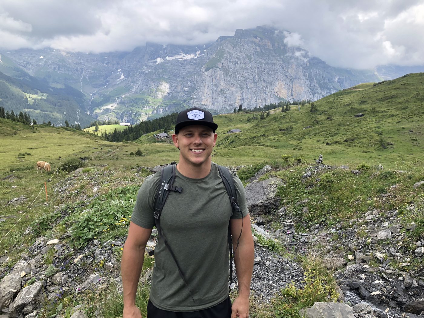 Bidwell Cranage hiking in the Swiss Alps with a peak behind him
